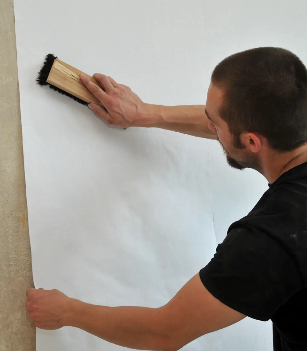 Funkel Service Ein Handwerker bringt eine Tapete an