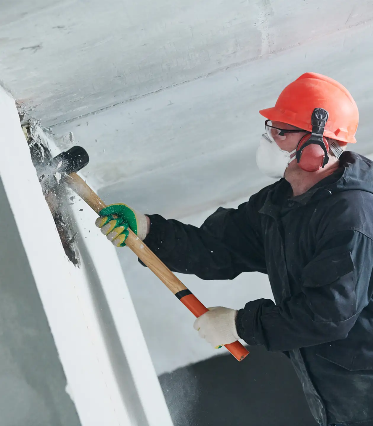 Funkel Service Arbeiter mit Schutzmaske beim Abriss einer Innenwand